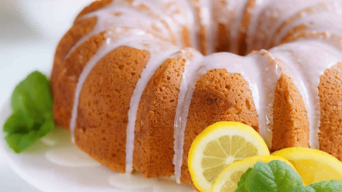 A bundt cake with lemon slices and mint leaves.