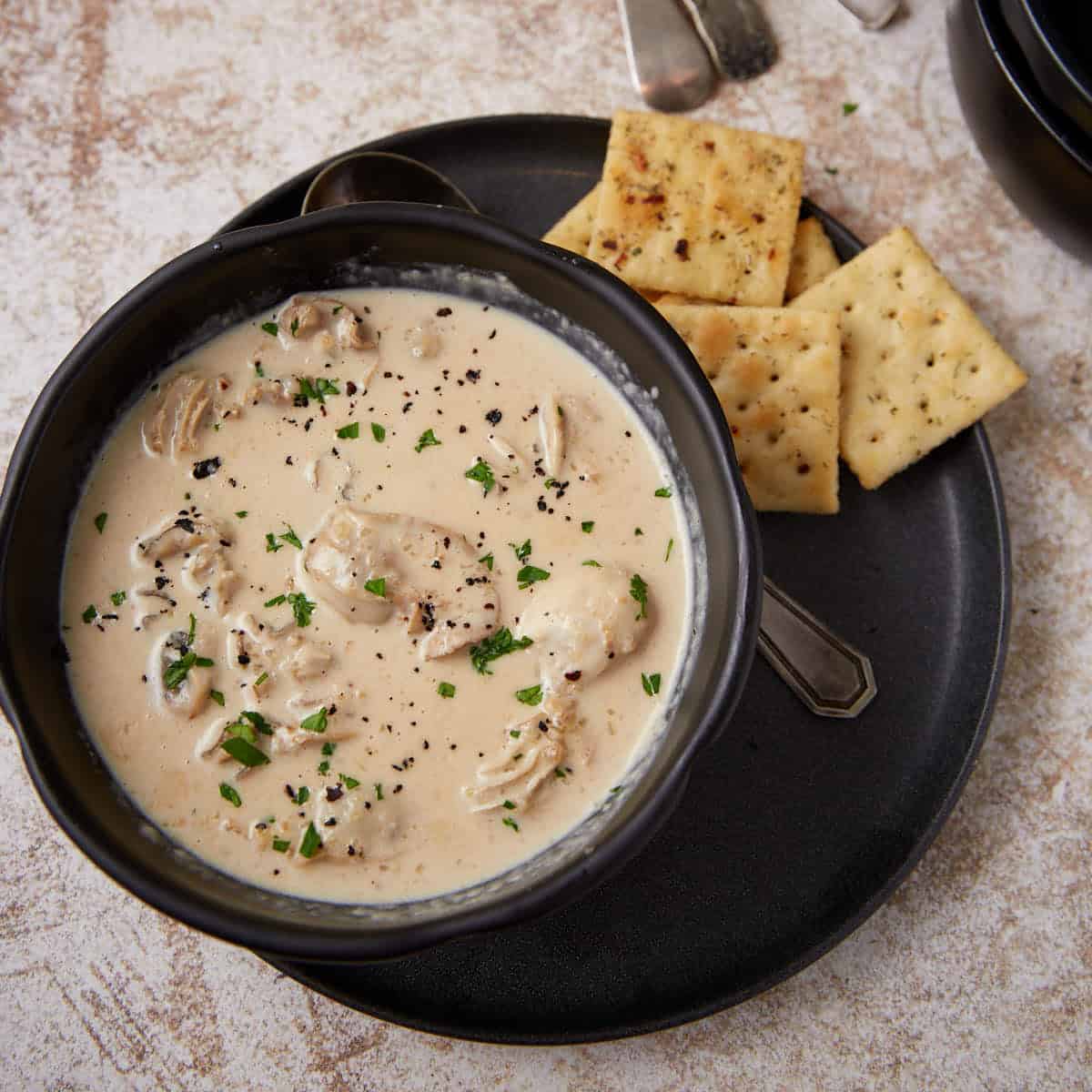 A seafood soup on a platter with fire crackers.