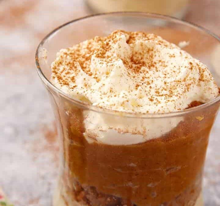 Pumpkin Mousse in small glasses with whipped cream on top.