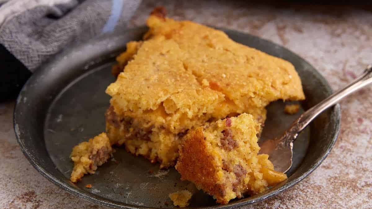 A slice of sausage cornbread on a plate.
