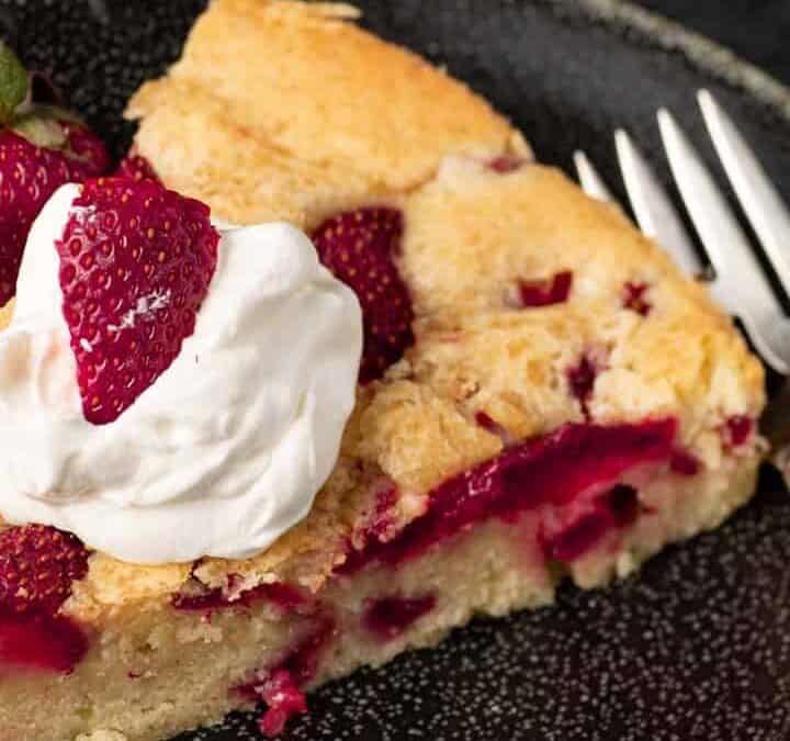 A slice of strawberry pound cake with whipped cream on top