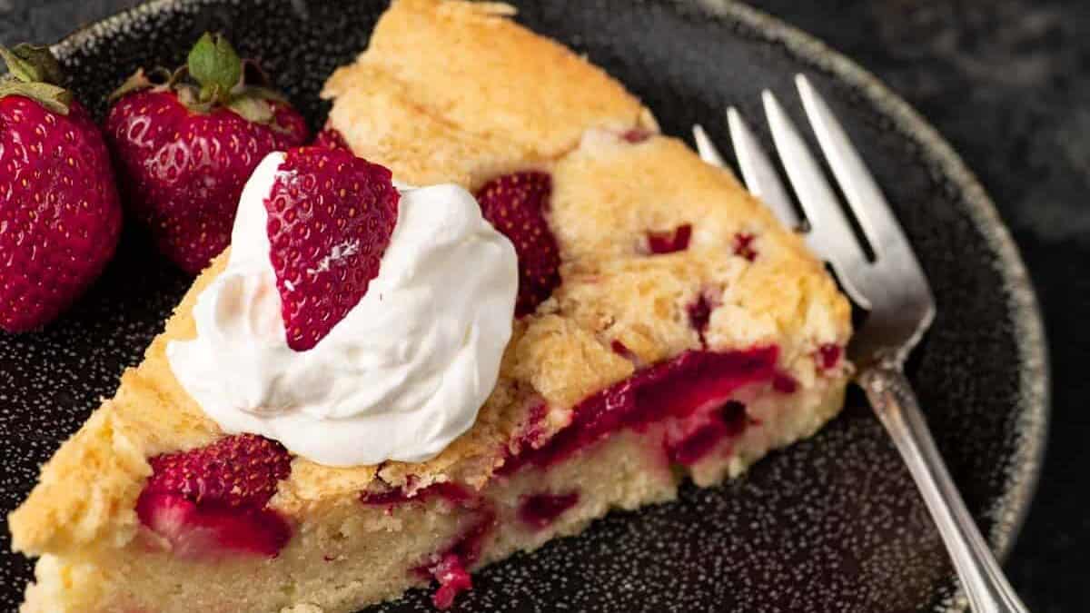 A slice of strawberry pound cake with whipped cream on top