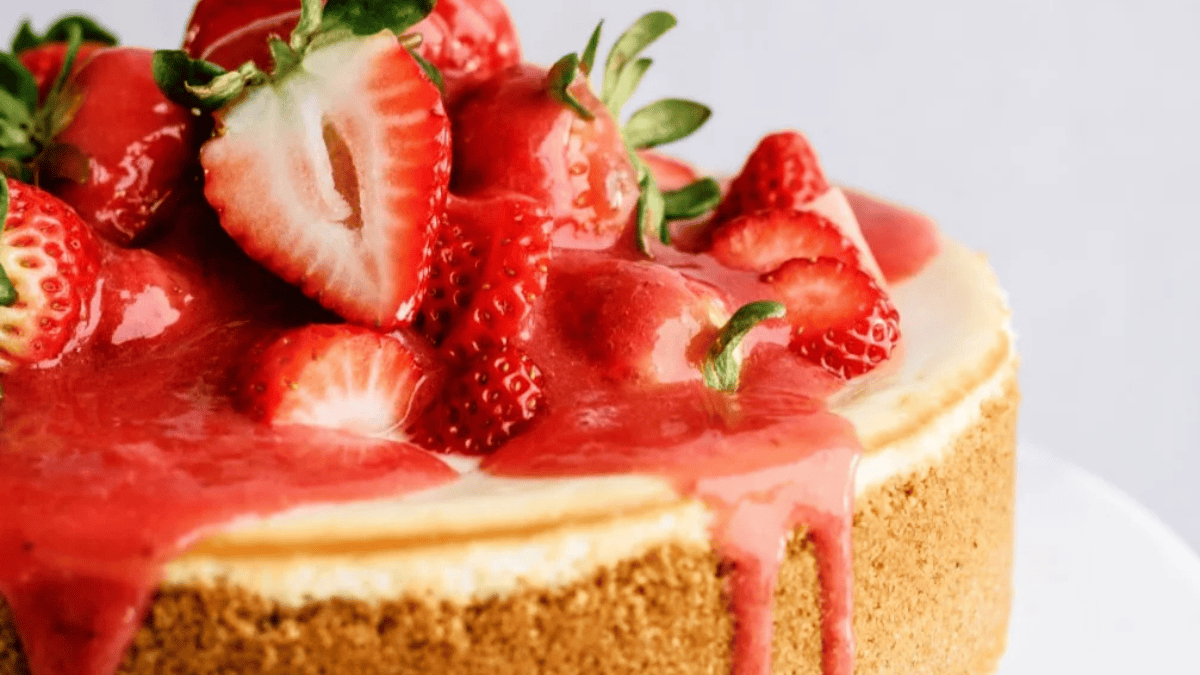 A cheesecake with strawberries and cream on top.