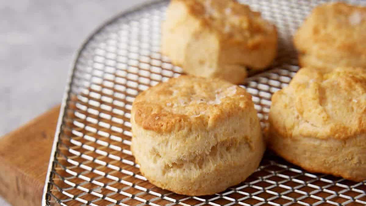 Tall flaky biscuits on the rack of an air fryer.