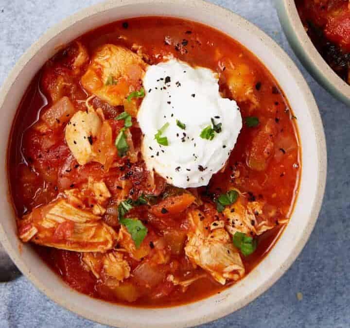 Red chicken chili scooped into three bowls.
