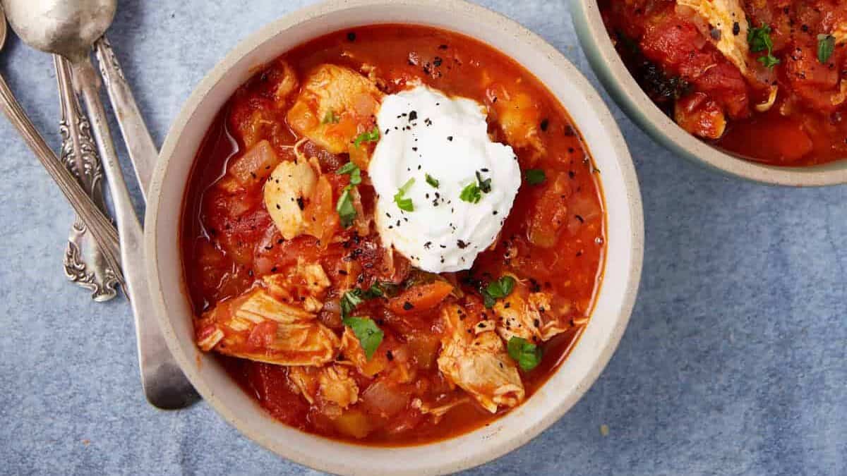 Red chicken chili scooped into three bowls.
