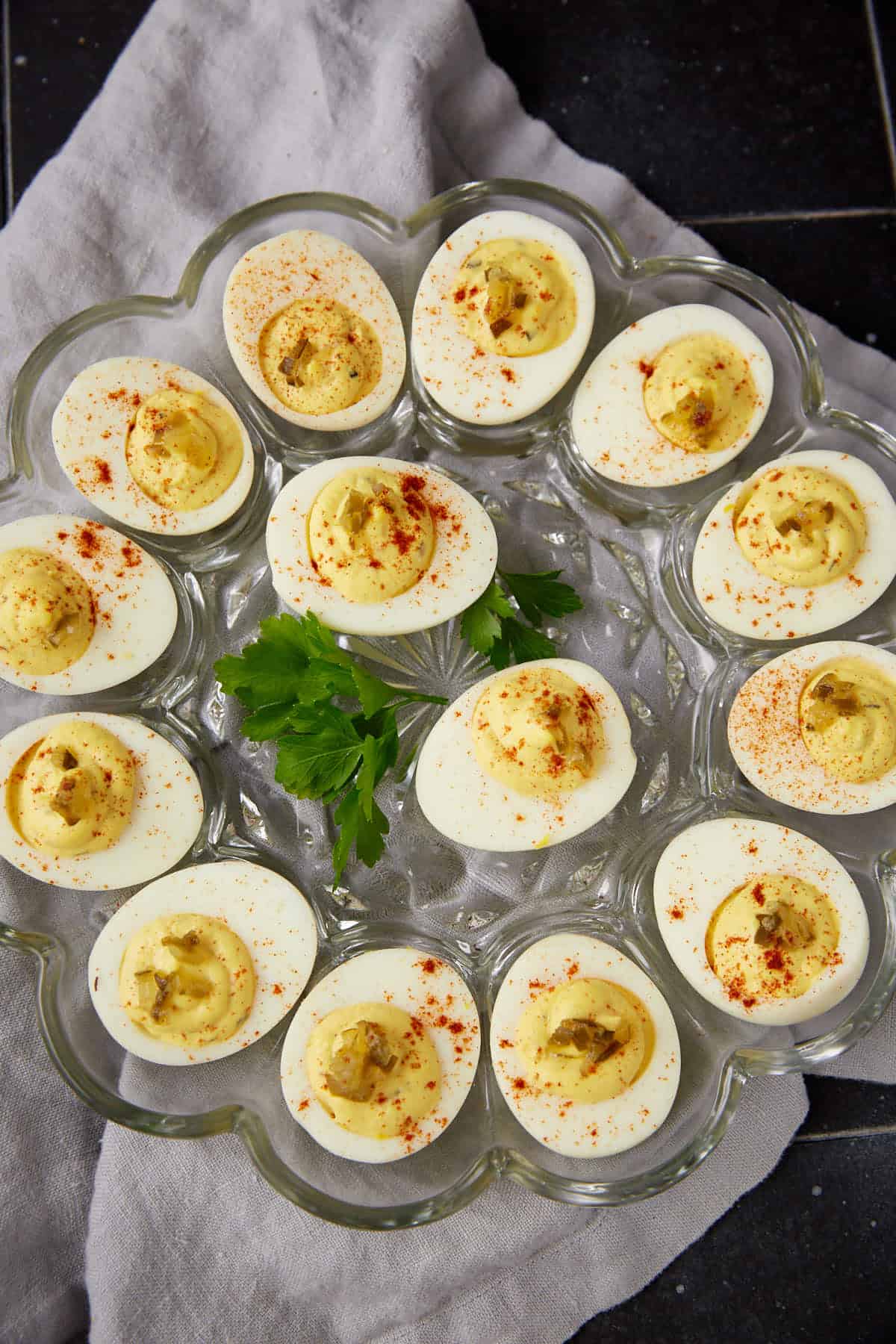a platter of deviled eggs with parsley on the platter.