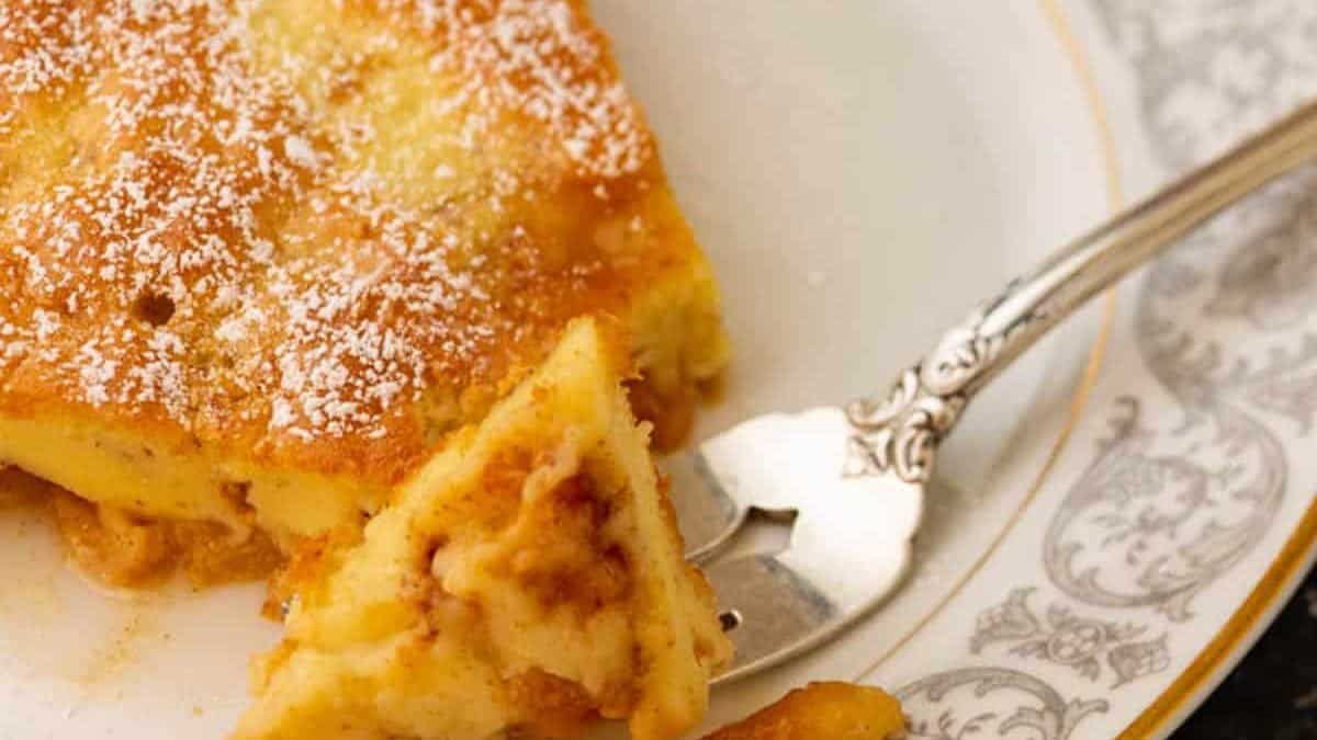 A fork full of a Dutch baby pancake on a plate.