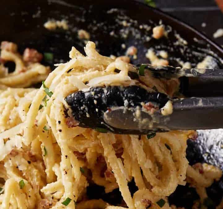 Tongs pulling up pasta.