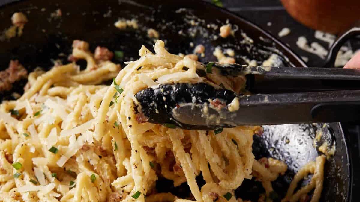 Tongs pulling up pasta.