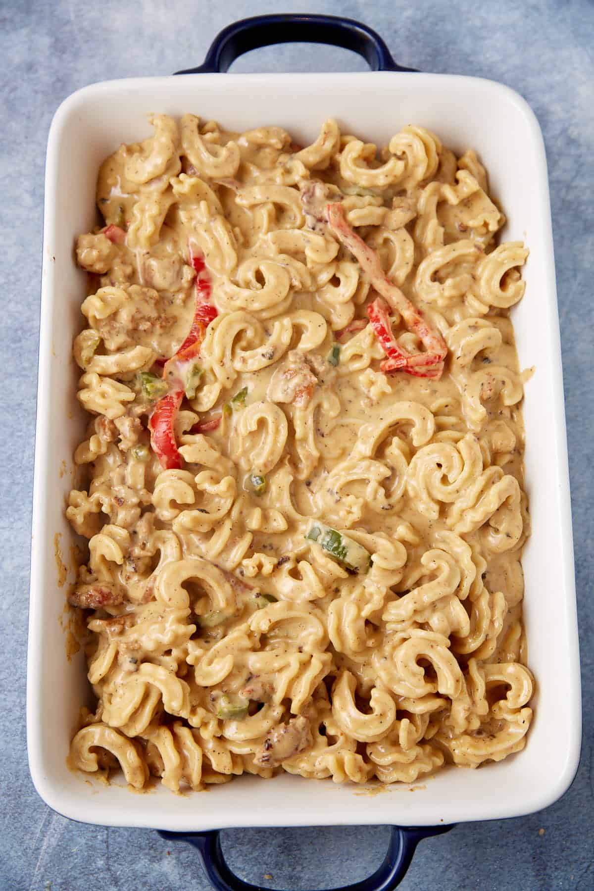 Pasta with peppers and sausage in a casserole dish.