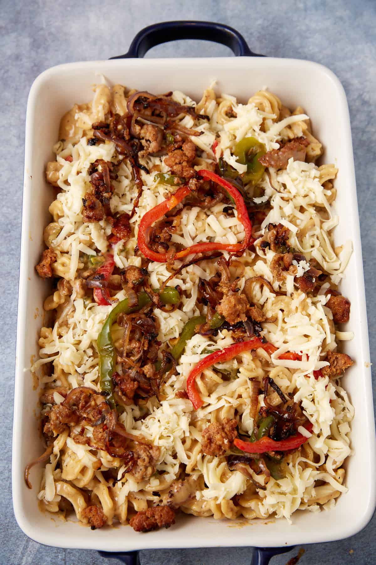 A pasta mac and cheese in a casserole dish before it has baked.