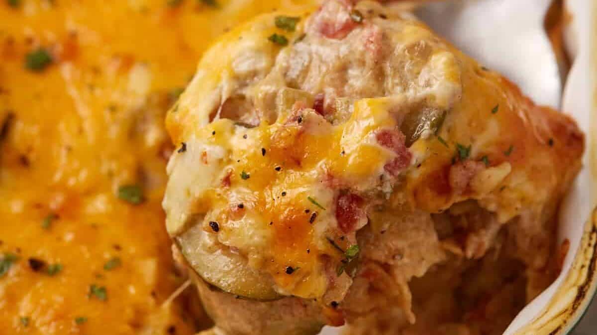 A serving spoon scooping out squash casserole.