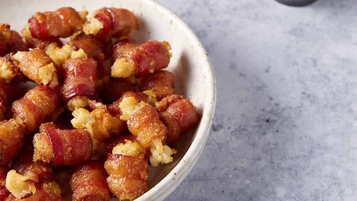 A serving bowl of tater tots wrapped in bacon.