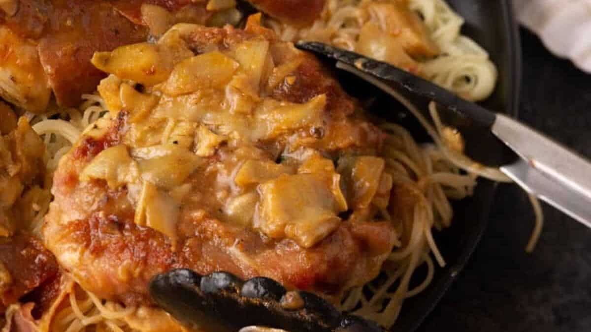 Tongs removing a serving of chicken saltimbocca