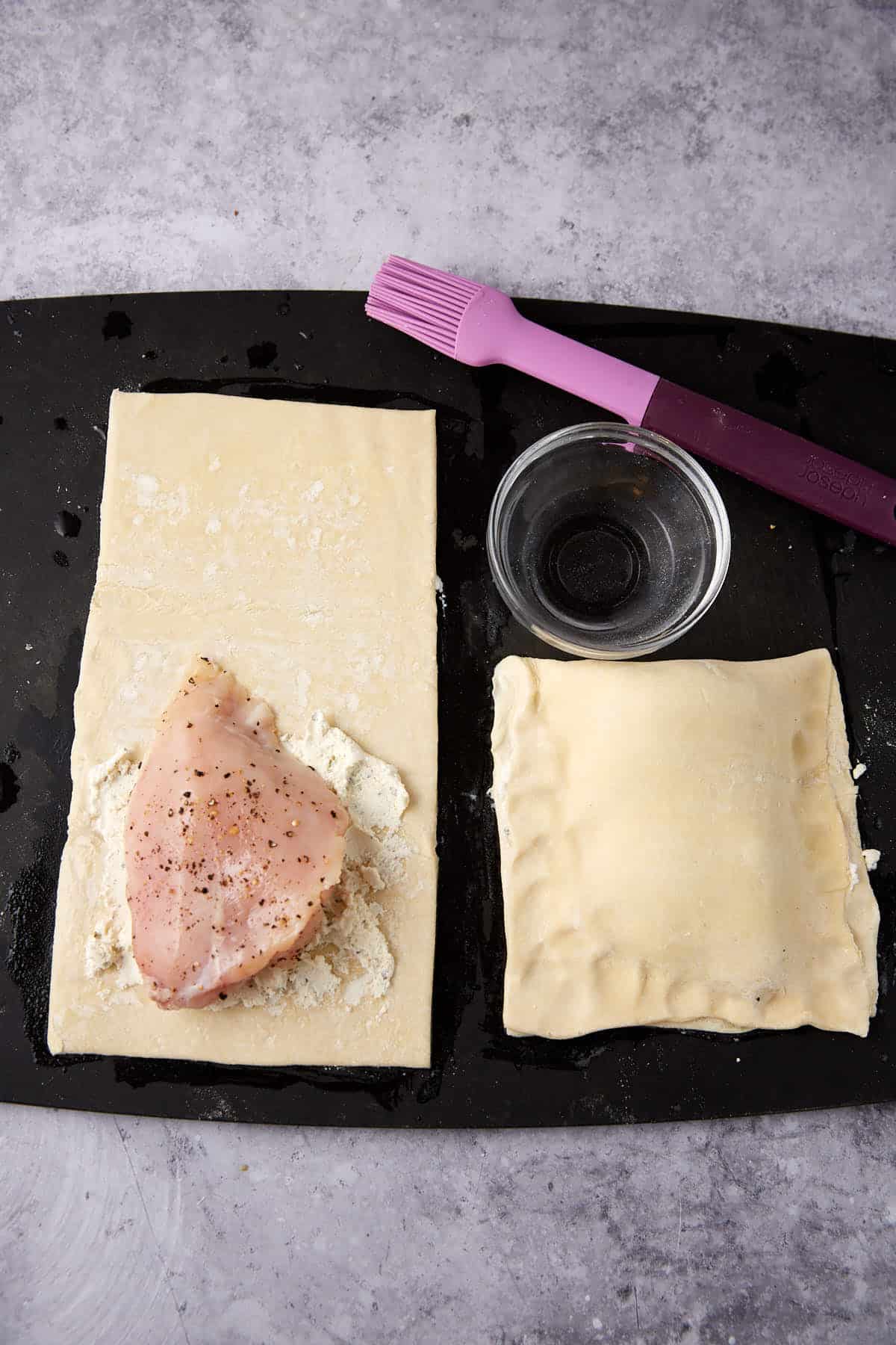 puff pastry sheets with garlic herb cheese and chicken on top, one is folded and the other is not.