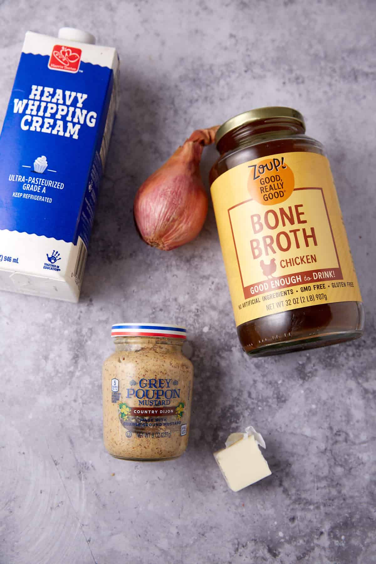 ingredients for mustard cream sauce on a gray background.