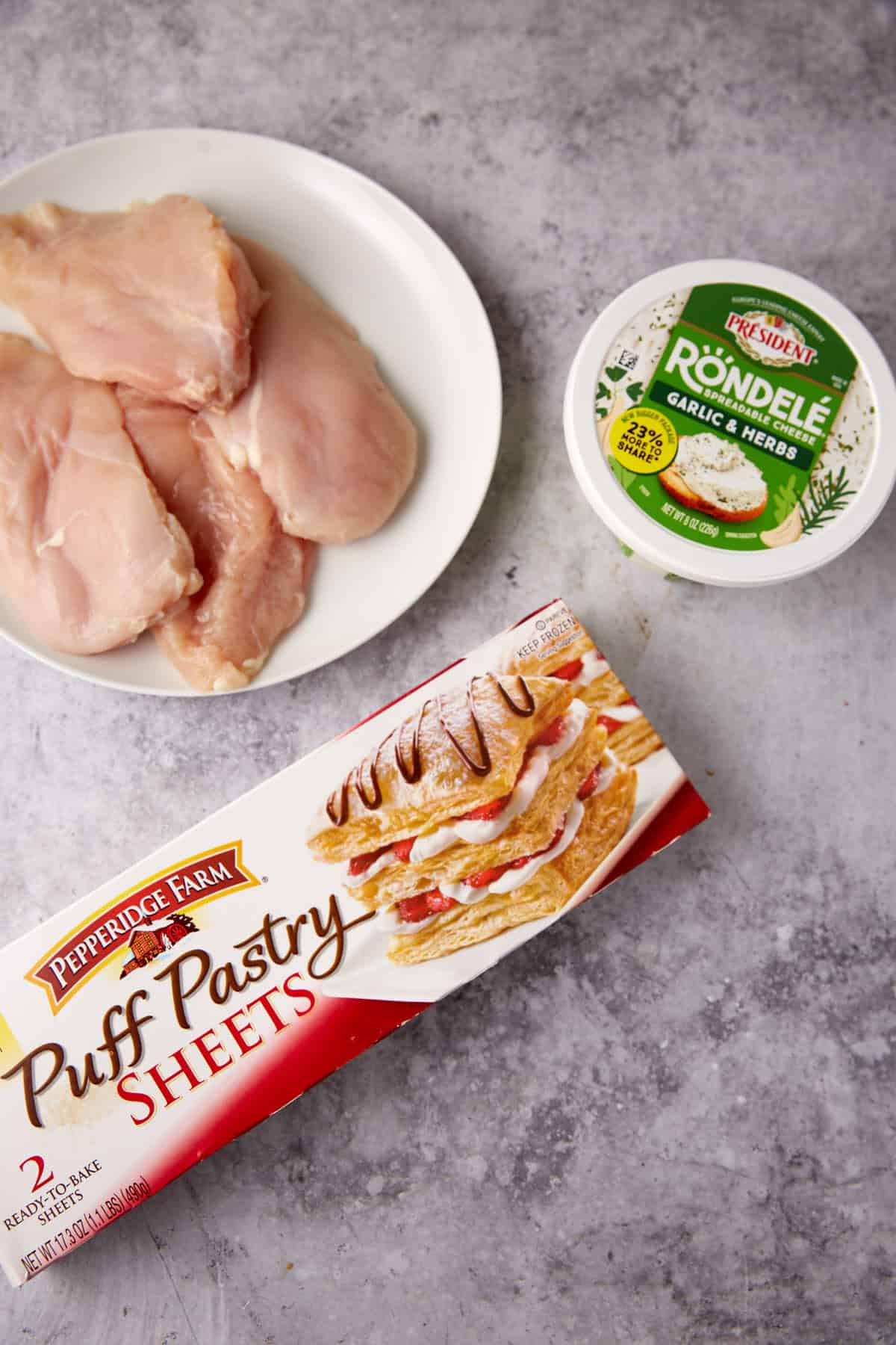 ingredients for chicken in puff pastry on a gray background.
