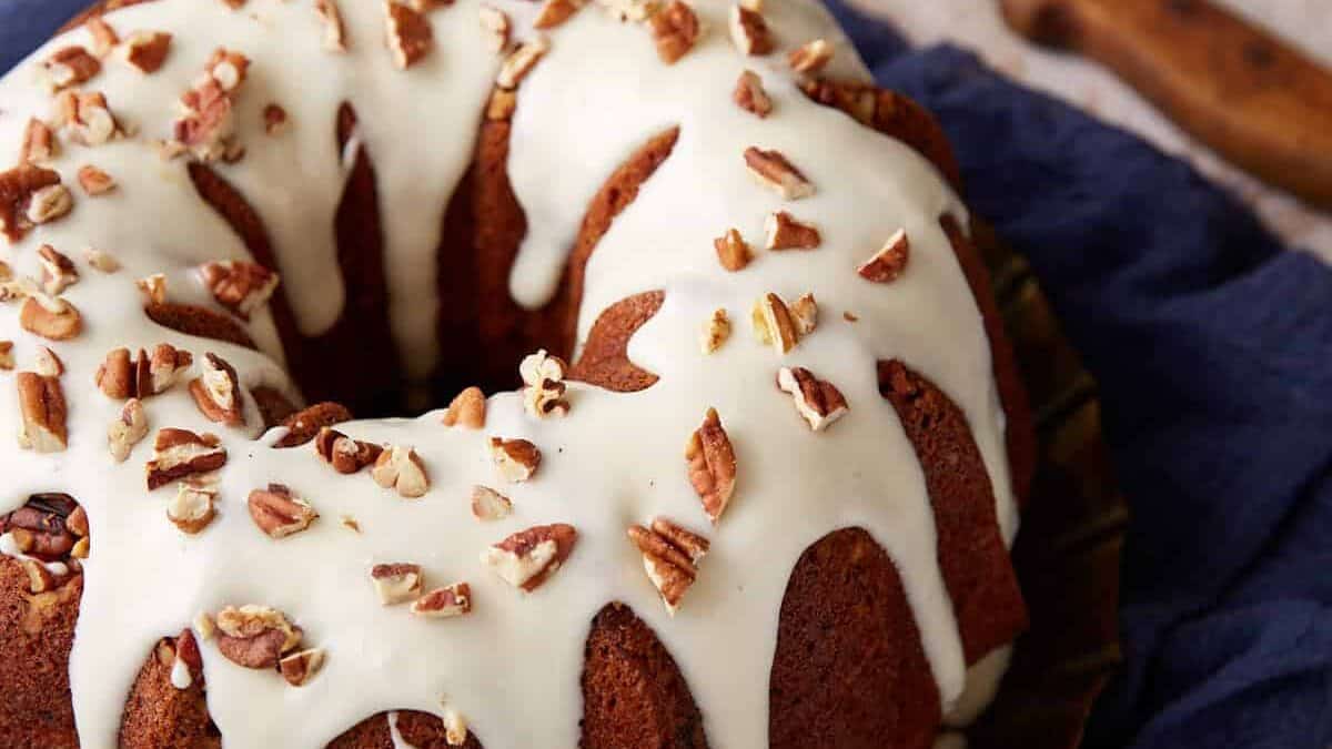 A frosted hummingbird cake next to a knife.
