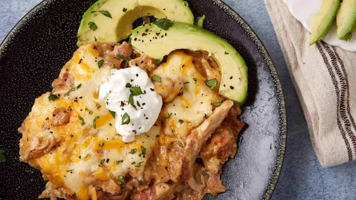 A serving of king ranch casserole with some avocados.