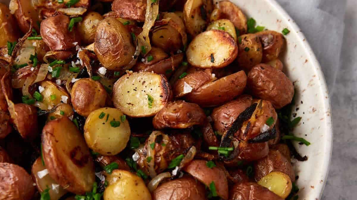 A serving bowl of crispy potatoes and onions.