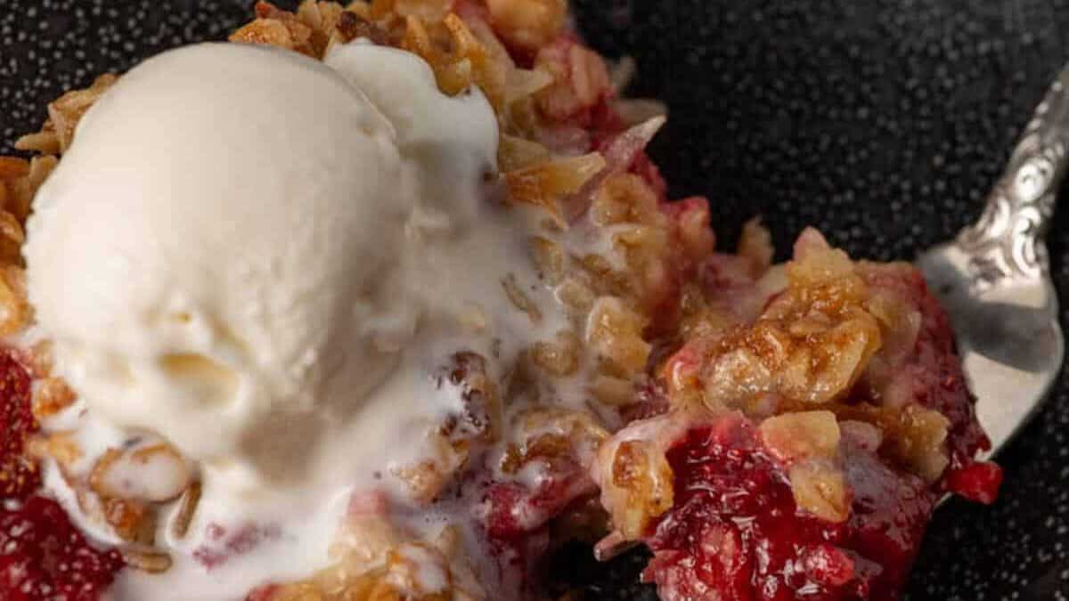 Strawberry crisp with vanilla ice cream on a plate with a flowered napkin