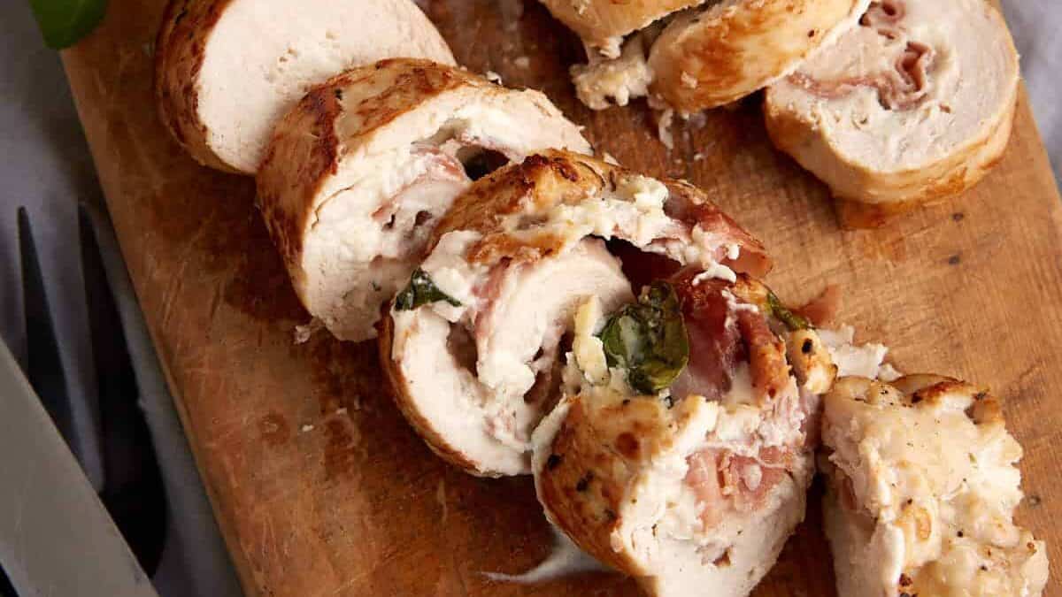 Two chicken breasts sliced on a cutting board.