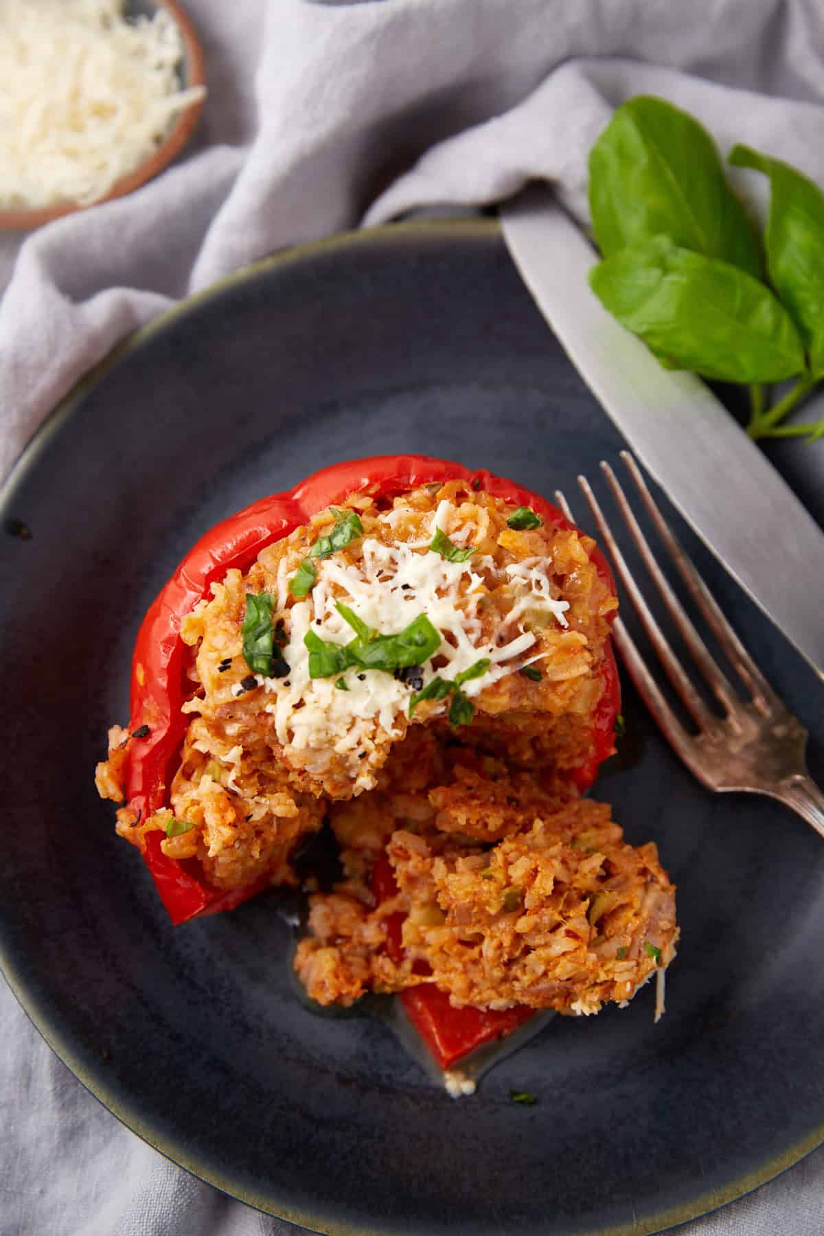 Italian sausage stuffed pepper on a black plate.