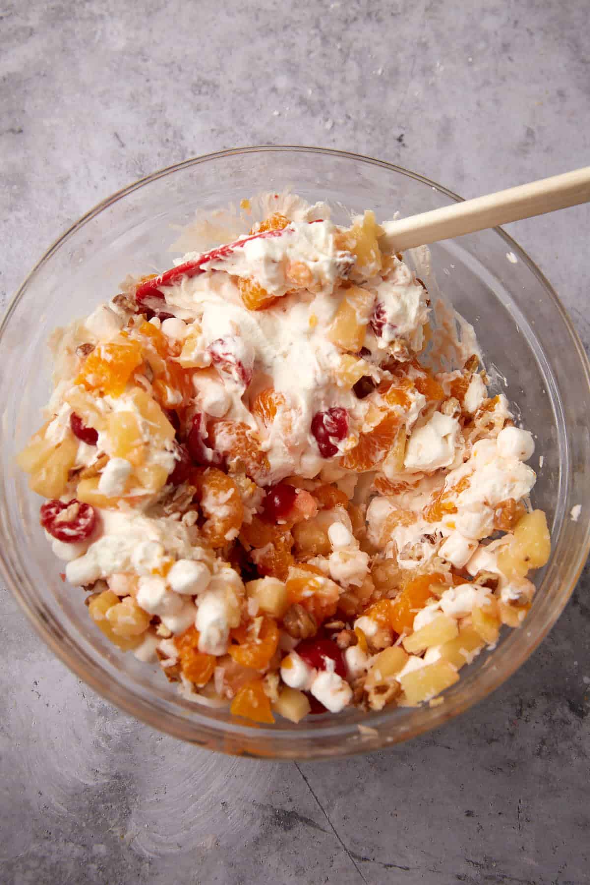 ambrosia salad mixture in a glass mixing bowl.