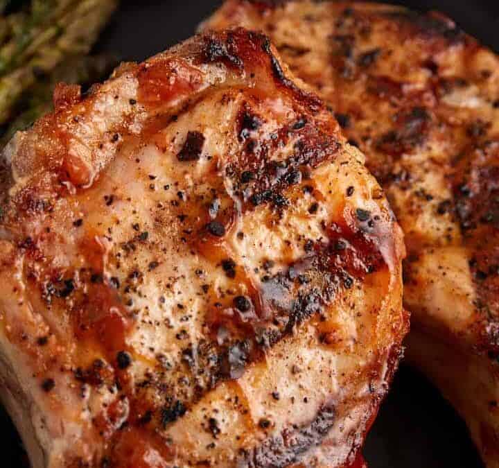 BBQ pork chops with peach sauce on a plate.