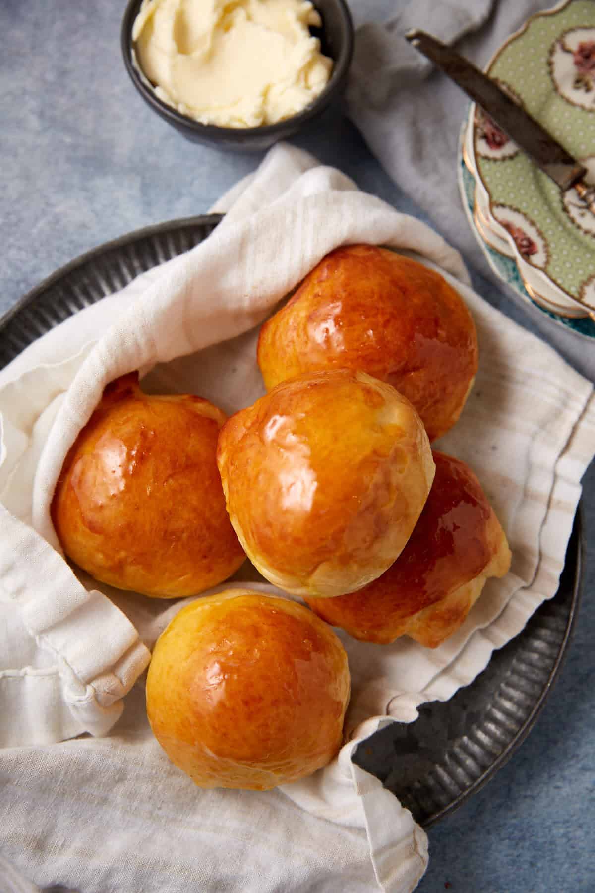 buttermilk yeast rolls on top of a towel on a plate. 
