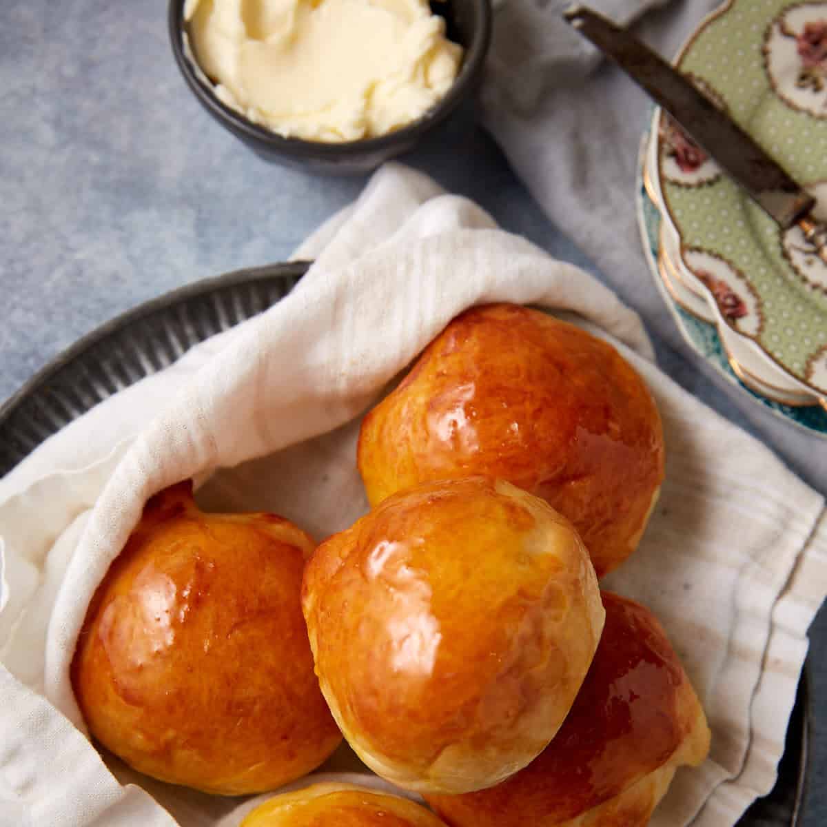 buttermilk yeast rolls on top of a towel on a plate.