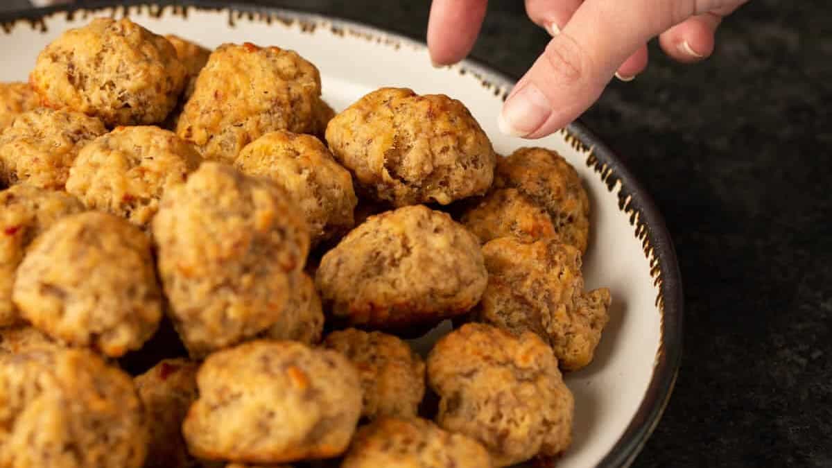 A sausage ball being taken from a platter.