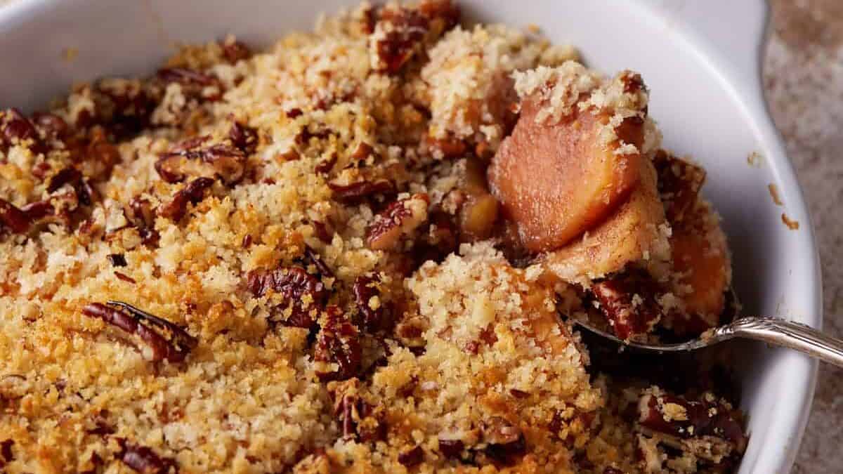 A spoon full of apples and sweet potatoes.