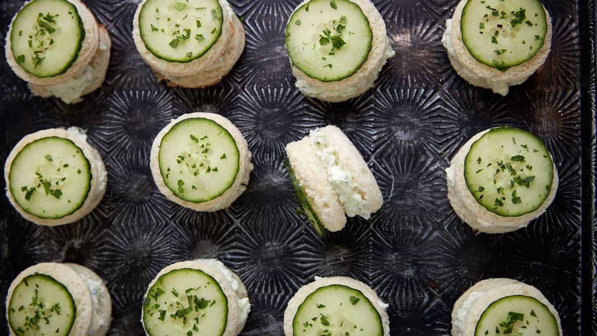 A tray of cucumber sandwiches lined in rows.