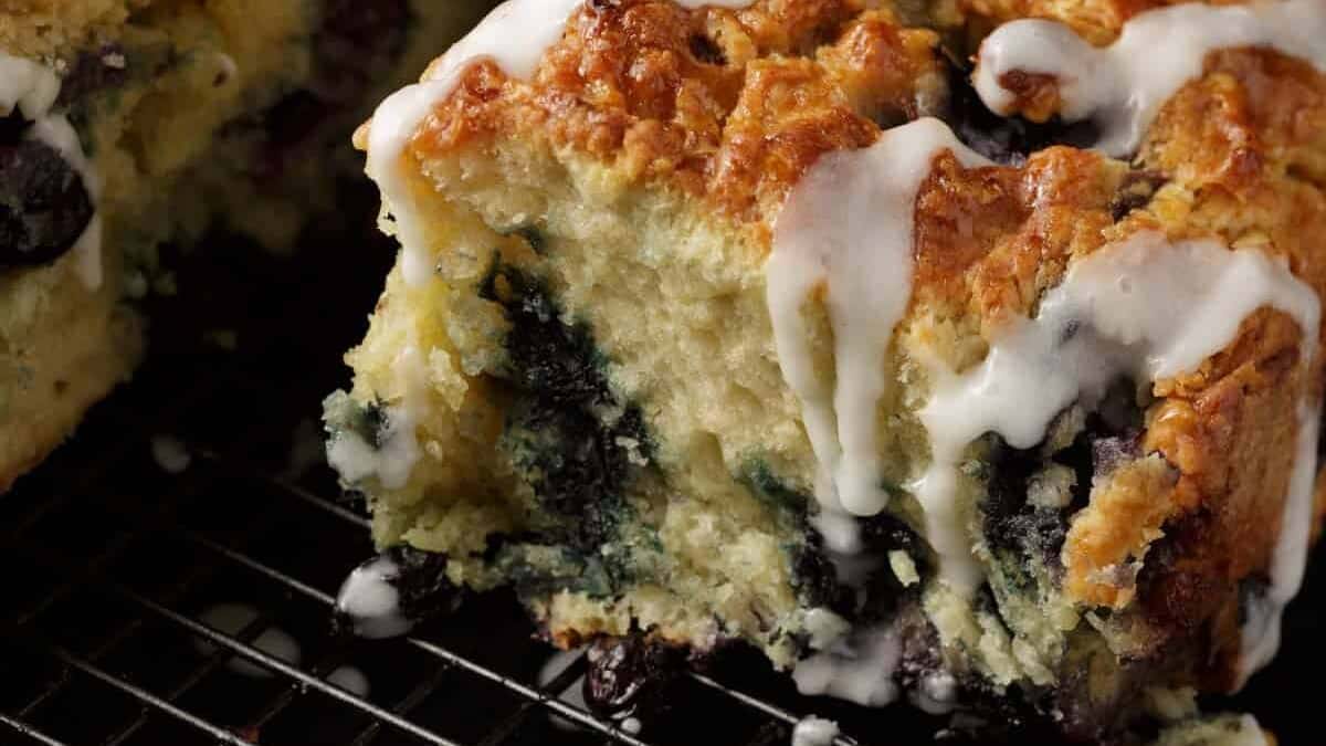 A batch of blueberry biscuits on a cooking rack.
