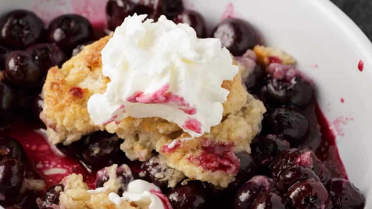A ramekin filled with Southern blueberry cobbler with a spoon.