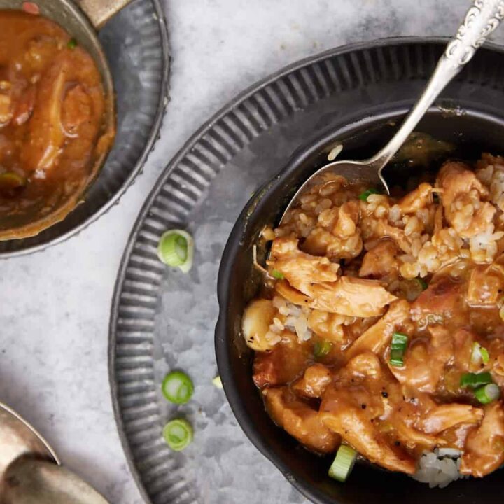 chicken and sausage gumbo in a bowl with the ladle on the side.