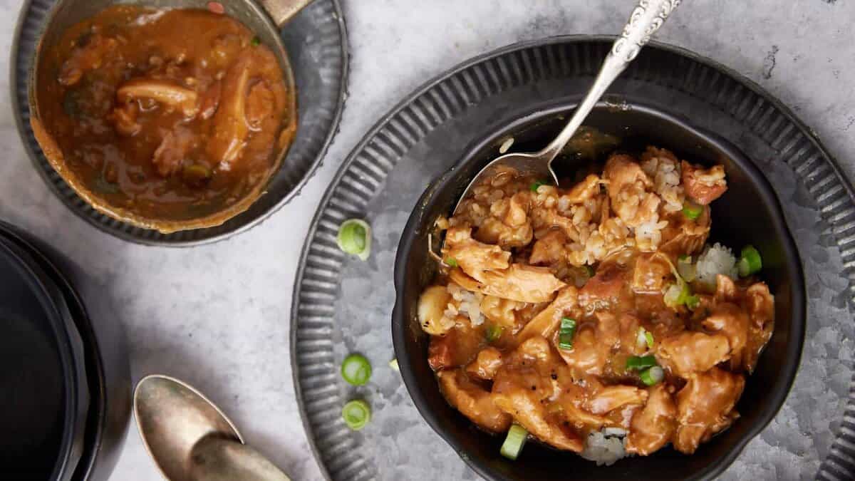 chicken and sausage gumbo in a bowl with the ladle on the side.