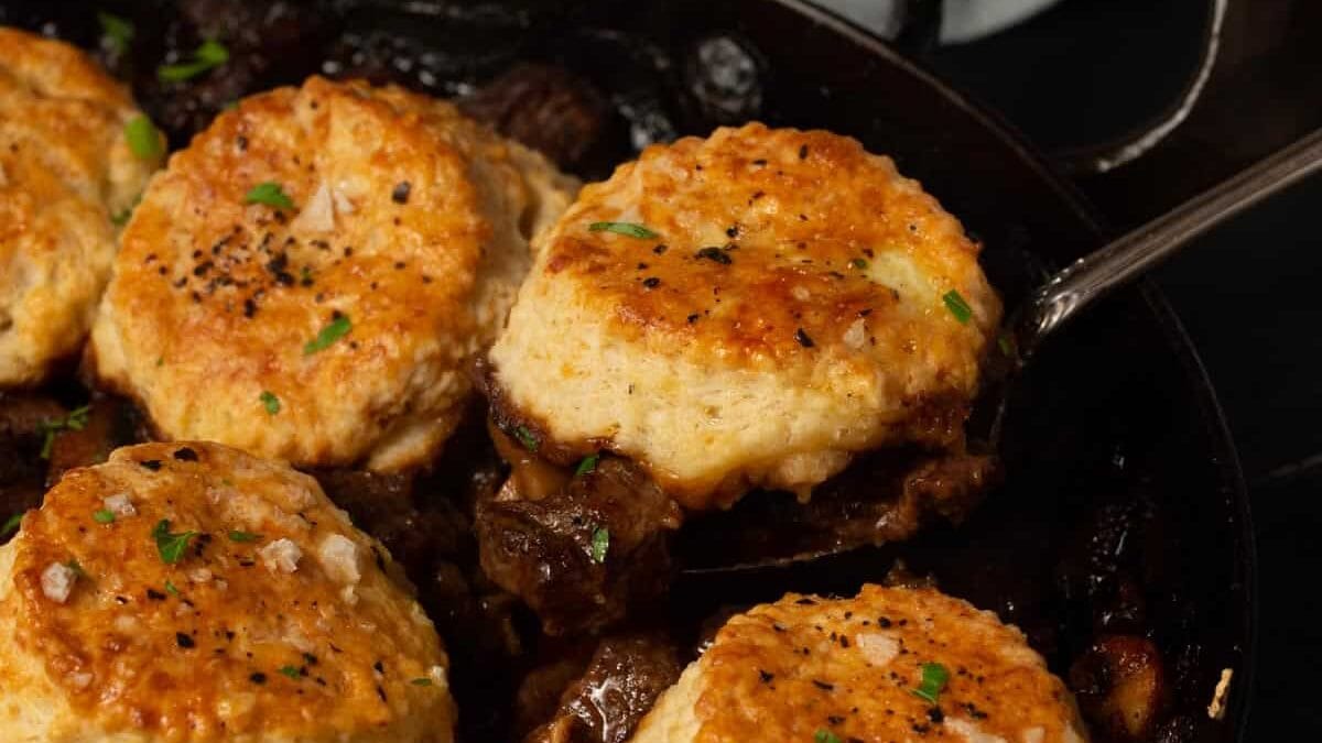 A skillet with Guinness pie topped with biscuits.