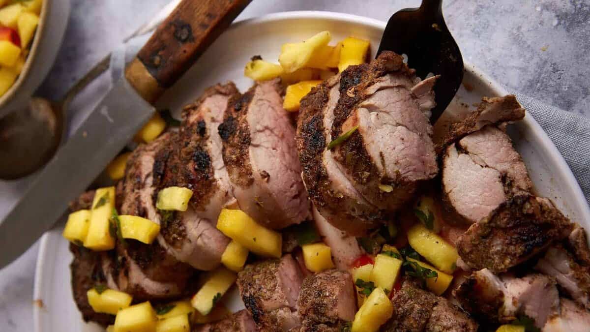 A platter of pork tenderloin with pineapple salsa.
