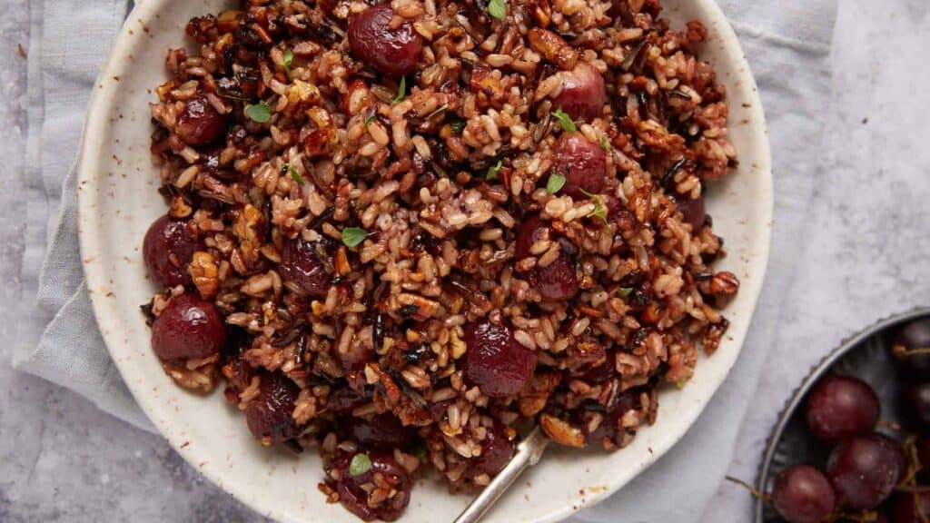 wild rice with roasted grapes in a white bowl.