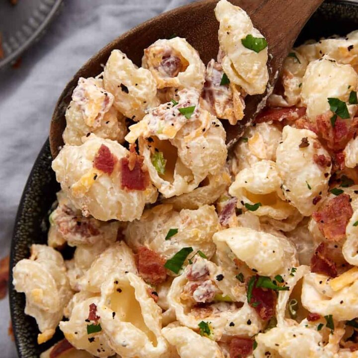 Ranch pasta salad in a bowl with a wooden spoon.