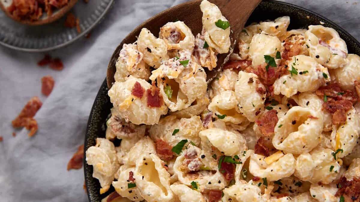 Ranch pasta salad in a bowl with a wooden spoon.