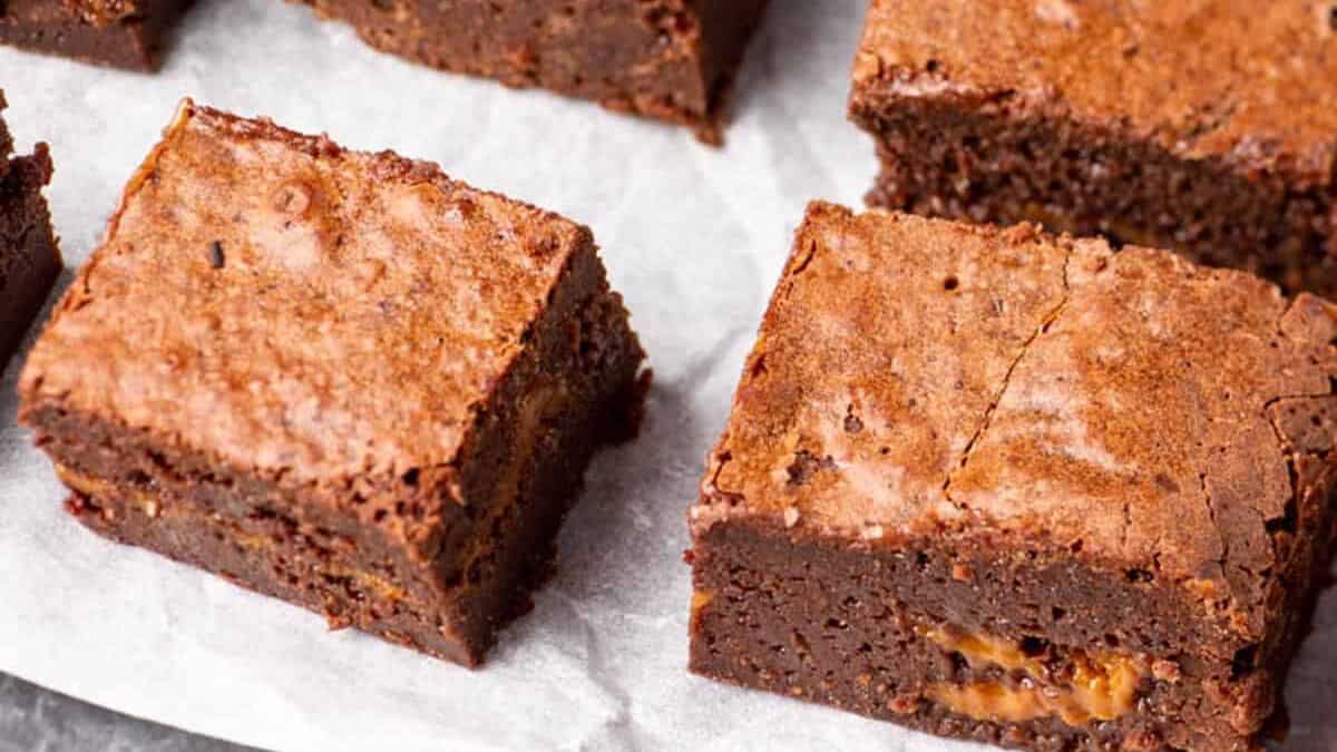 Dulce de leche brownies cut on parchment paper