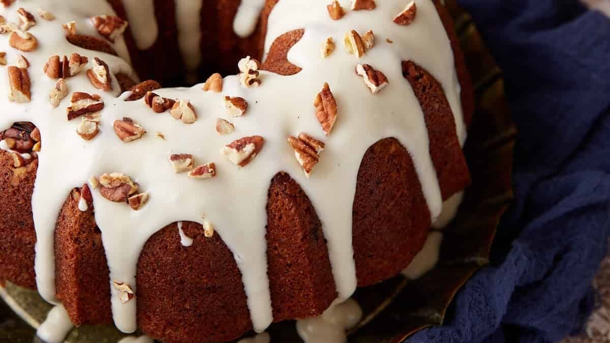 A frosted hummingbird cake next to a knife.