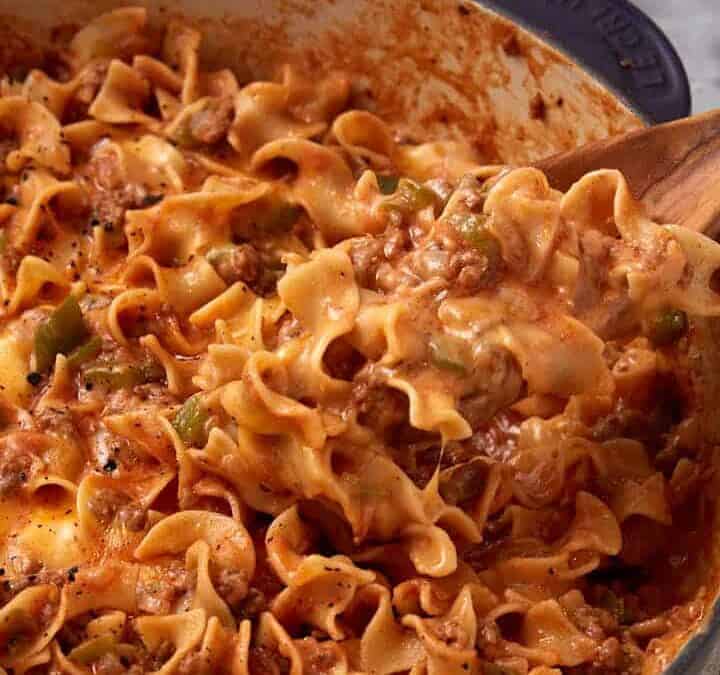 A wooden spoon with a serving of hamburger casserole.