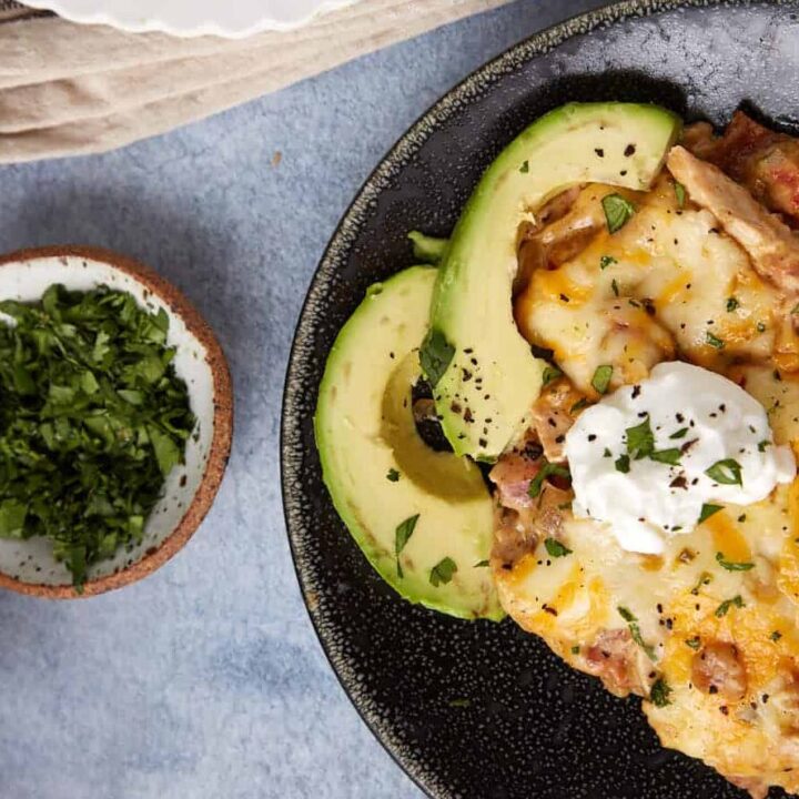 A serving of king ranch casserole with a sliced avocado.