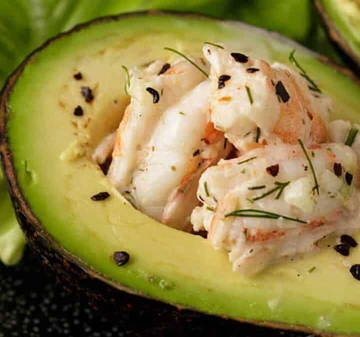 An avocado filled with shrimp salad inside.