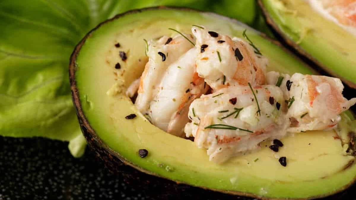 An avocado filled with shrimp salad inside.